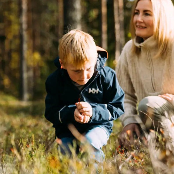 Henrik plukker bær i skogen med familien